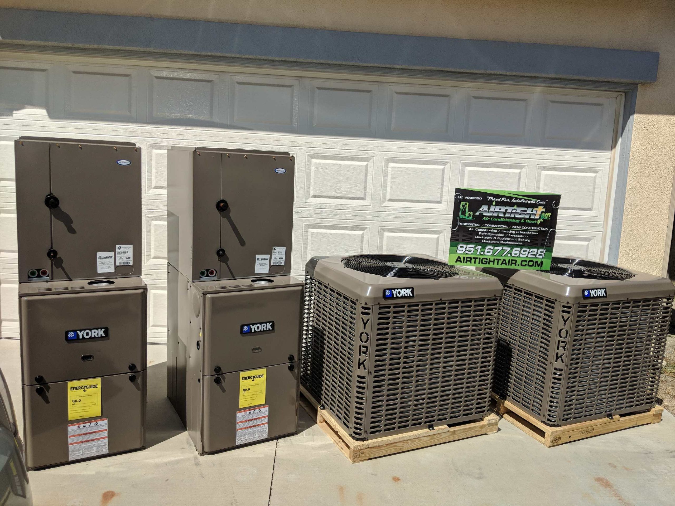 Several heating and cooling units outside of a residential garage