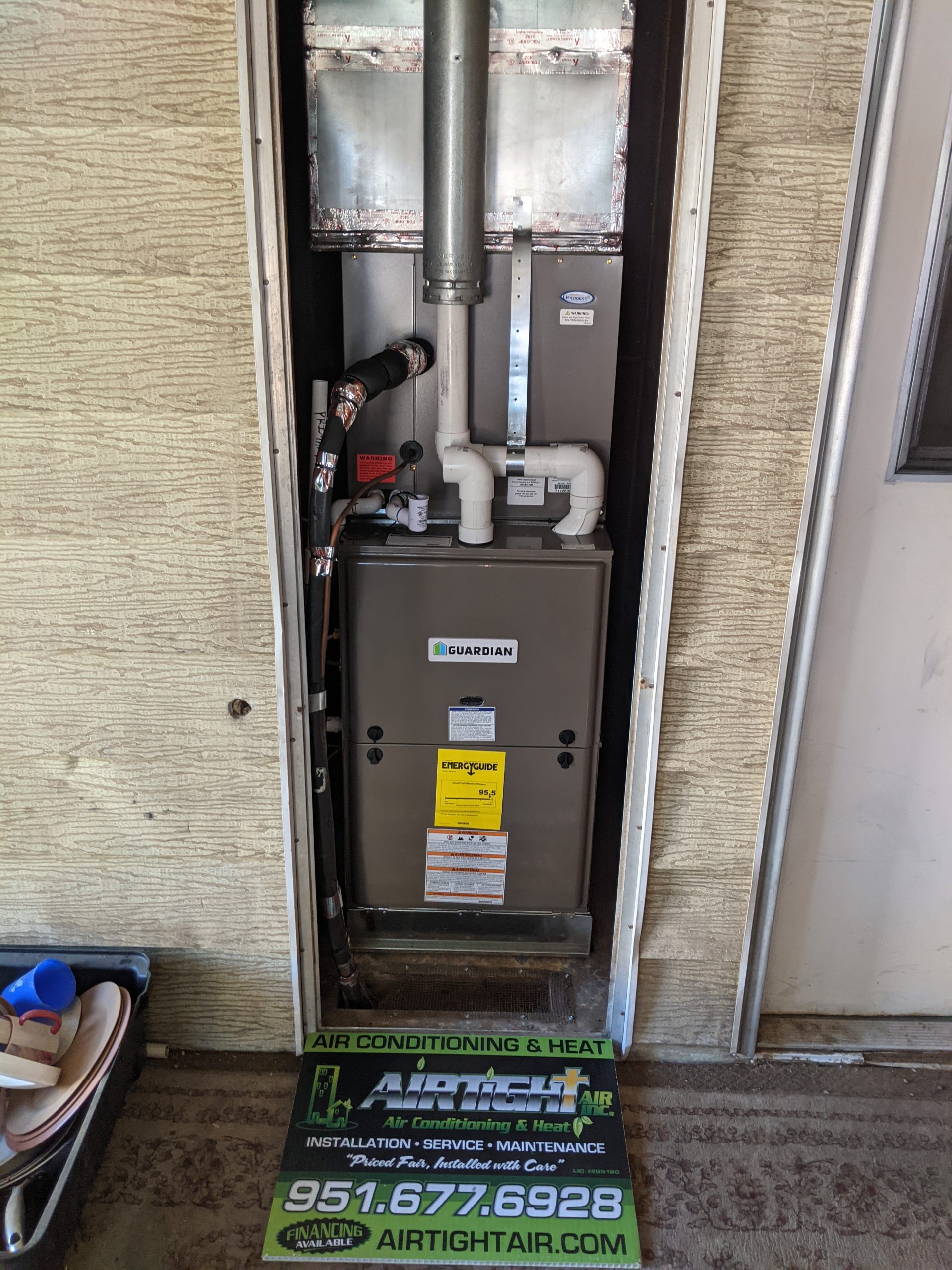 A Guardian AC unit inside a wall next to a door